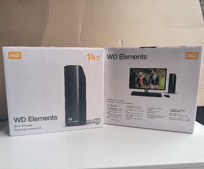 des cartons posés sur une table sur laquelle se trouvent une télévision et un ordinateur portable