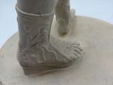 a statue of a person standing on top of a plate