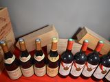 several bottles of wine are lined up on a red table