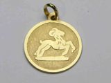 une photo d'un pendentif en or sur lequel figure un cheval