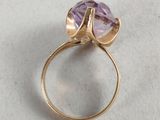 a close up of a gold ring with an amethorate stone