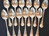 six silver spoons are arranged in a row on a black surface