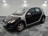 une petite voiture noire et blanche garée dans une pièce
