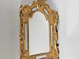 un miroir doré accroché au mur d'une pièce