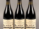 trois bouteilles de vin posées sur une table l'une à côté de l'autre