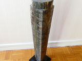 a tall vase that is sitting on a wooden floor