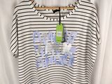 un t-shirt rayé blanc et noir avec une étiquette verte dessus