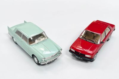 deux voitures jouets assises l'une à côté de l'autre sur une surface blanche