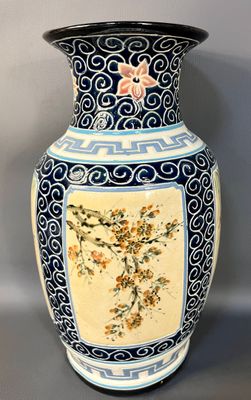 a vase with a floral design on it sitting on a table