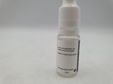 a bottle of liquid sitting on a white surface