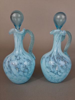 deux vases bleus posés l'un à côté de l'autre sur une table