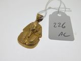 un pendentif égyptien en or sur lequel est apposée une étiquette de prix