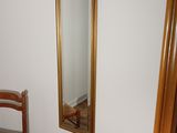 a chair and a mirror in the corner of a room