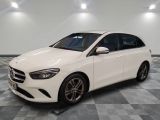 une Mercedes Classe B blanche garée sur un sol à damier