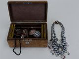 une boîte en bois contenant tout un tas de bijoux