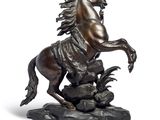 bronze statue of a horse on a rock on a white background