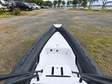 a boat that is sitting in the grass by the water