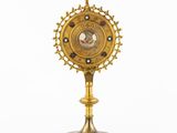 an image of a golden clock on a stand on a white background
