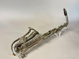 un saxophone plaqué argent posé sur une surface blanche