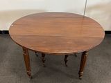 une table en bois à deux pieds avec un plateau rond