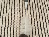 a brush that is laying on the floor next to a piece of cloth