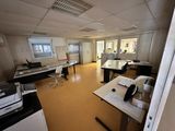 une salle avec de nombreux bureaux et une imprimante