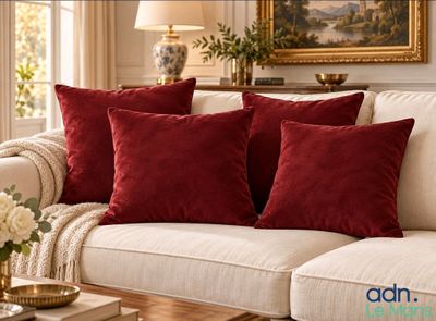 three red pillows on a white couch in a living room