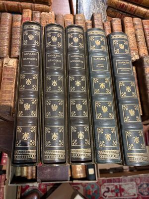 Plusieurs vieux livres sont empilés sur une table dans une bibliothèque