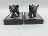 pair of black elephant bookends with tusks on wooden bases