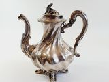 silver plated tea pot with a bird on the top