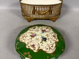 an image of a green and gold box with a basket on top