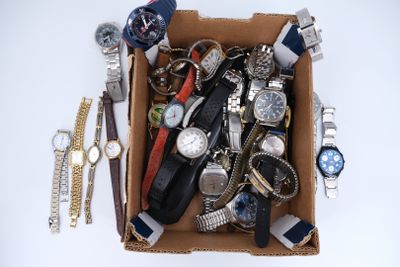une boîte remplie de montres et d'autres montres posées sur une table