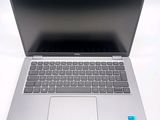 a silver laptop with a black keyboard on a white surface