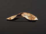 a close up of a gold leaf brooch with diamonds