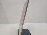 an ipad is sitting on a stand on a white surface