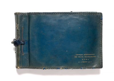 un vieux livre à la couverture bleue posé sur une surface blanche