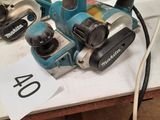 two electric tools are sitting on a table in a workshop