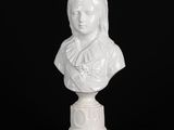 un buste de femme en marbre blanc posé sur un socle, sur fond noir