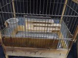 a cage with a bird inside of it on the floor