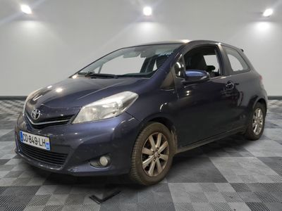 La voiture bleue est garée dans une pièce dont le sol est en damier.