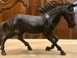 une statue représentant un cheval au galop posée au sol