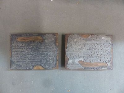 two pieces of metal with writing on them on a table