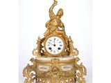 a gold clock sitting on top of a marble table