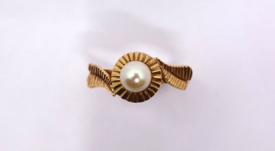 a close up of a gold ring with a pearl in it