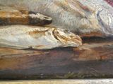 un tableau représentant un poisson et une tête de poisson posés sur une table