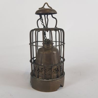 une lanterne en métal à l'ancienne, surmontée d'une cage à oiseaux