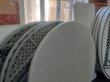 four white plates stacked on top of each other on a table