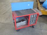 a small red cart with a blue box on top of it