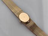 a close up of a gold watch on a white surface