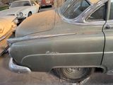 an old car that is parked on the side of the street